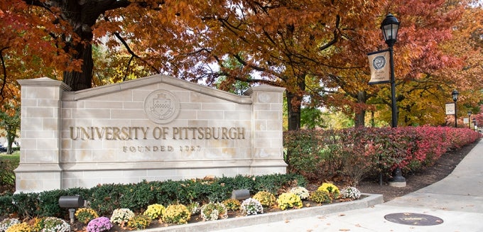 University of Pittsburgh stone sign surrounded by fall foliage