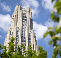 The Cathedral of Learning surrounded by green leaves