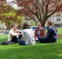 Students sitting in a field photo